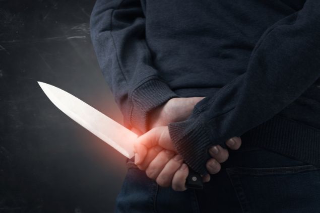 Imagem de um homem com uma faca na mão atrás das costas