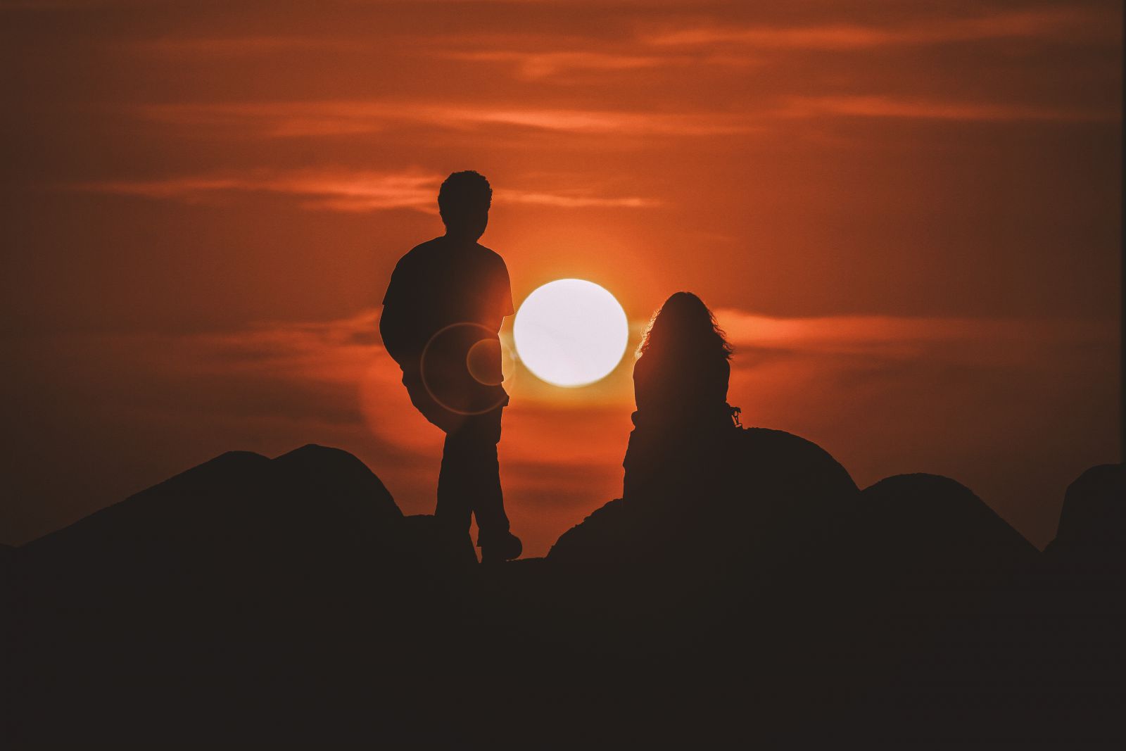 Silhueta de homem e mulher no pôr-do-sol.