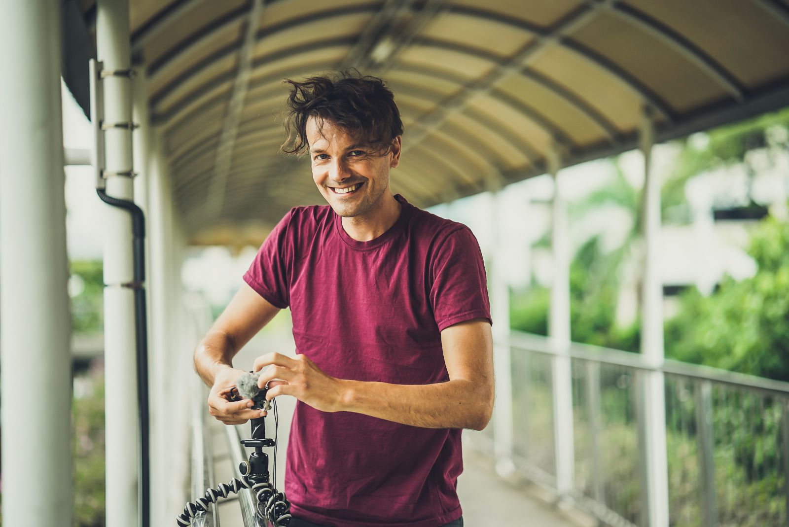 Homem sorrindo segurando sua bicicleta 