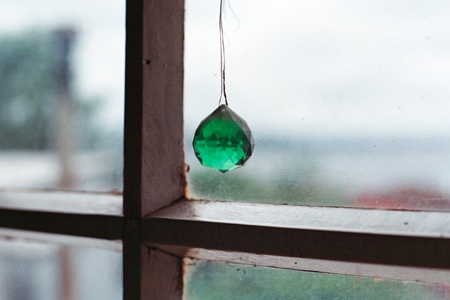 Pedra verde pendurada numa janela.