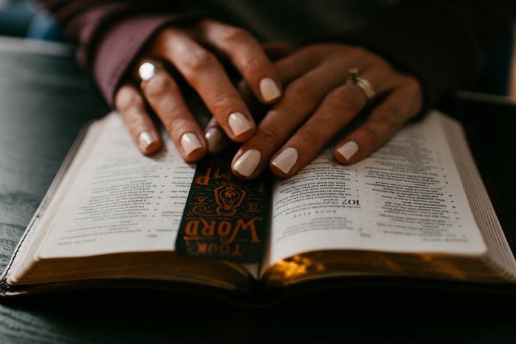 Mãos sob uma Bíblia aberta