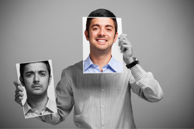 Homem mudando de humor segurando um papel com seu rosto feliz e bravo