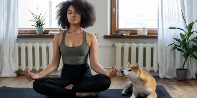 Mulher meditando em casa com cachorro ao lado