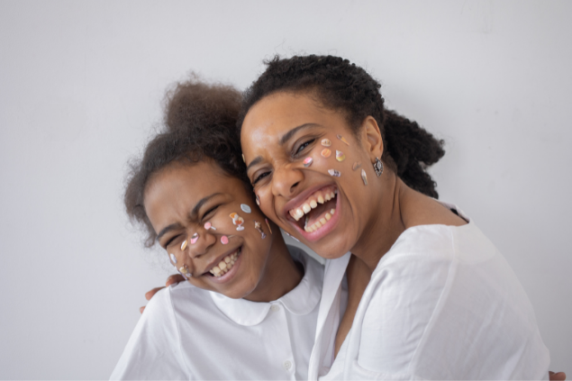 Mulher abraçando outra mulher e sorrindo