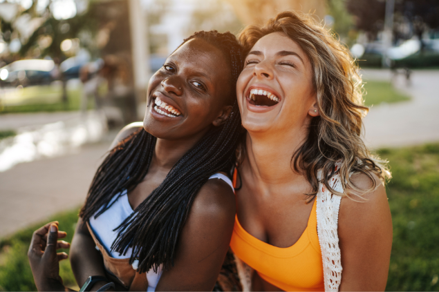 Duas mulheres sorrindo e se abraçando