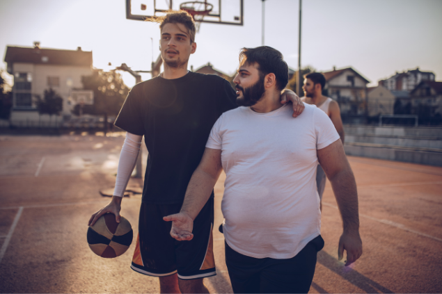 Dois amigos abraçados em uma quadra de basquete