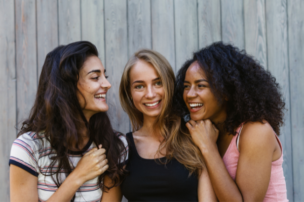 Três meninas conversando e rindo