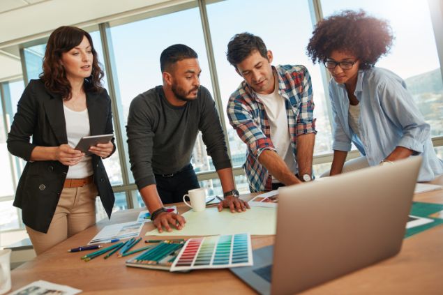 Imagem de 4 colegas de trabalho, trabalhando em equipe