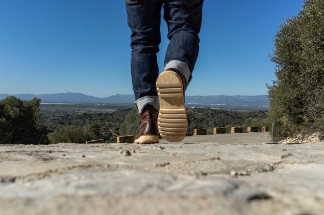 Pés masculinos, indo em direção à estrada como se estivesse indo embora 