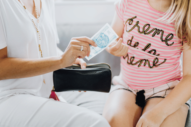 Mãe dando mesada para a filha. 