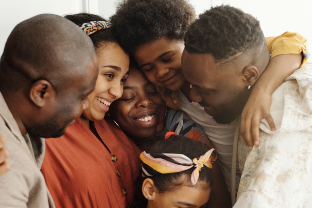 Seis pessoas da família se abraçando e sorrindo