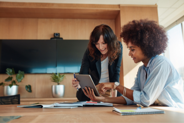 Duas mulheres trabalhando enquanto verificam algo em um tablet