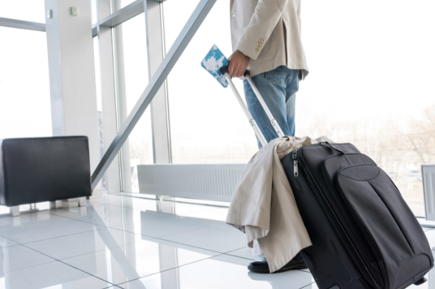 Homem com mala de viagem em aeroporto