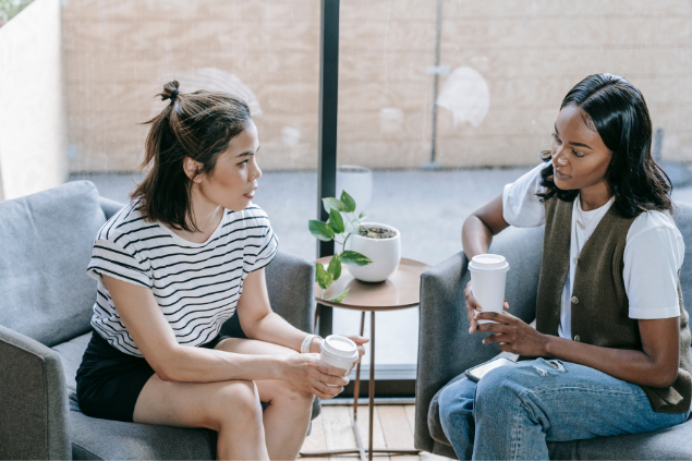 Duas mulheres sentadas em poltronas conversando