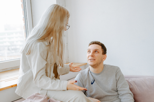 Homem e mulher conversando, sentados no sofá