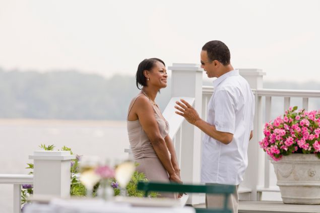 Imagem de um casal conversando. Ao fundo, um lindo lago.