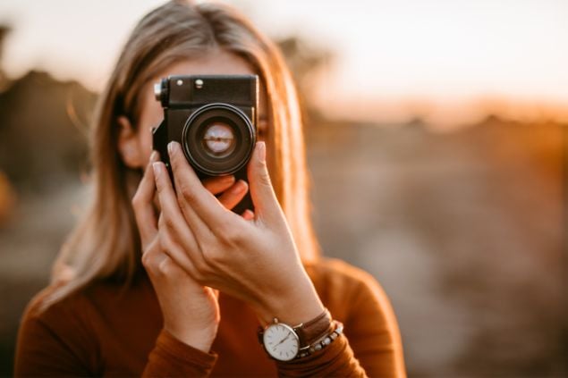 Imagem de uma mulher fotógrafa fotografando momentos de outono