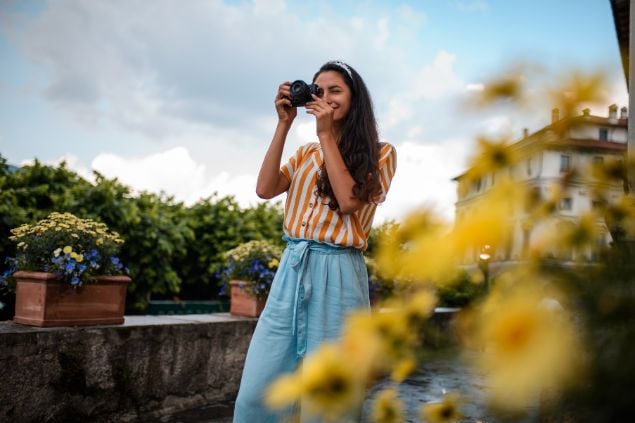 Imagem de uma mulher fotógrafa fazendo fotos de lugares incríveis.