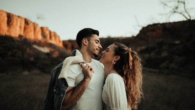 Homem e mulher brancos com os rostos próximos.