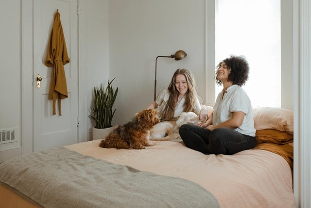 Mulheres sentadas numa cama.