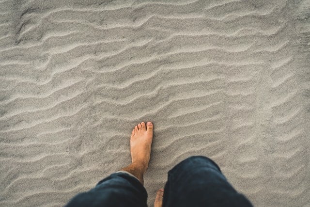 Pés brancos na areia.