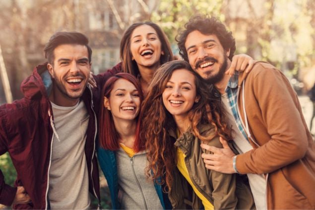 Um grupo de amigos sorrindo e olhando na câmera