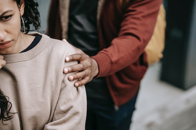 Homem negro encostando em ombro de mulher negra.