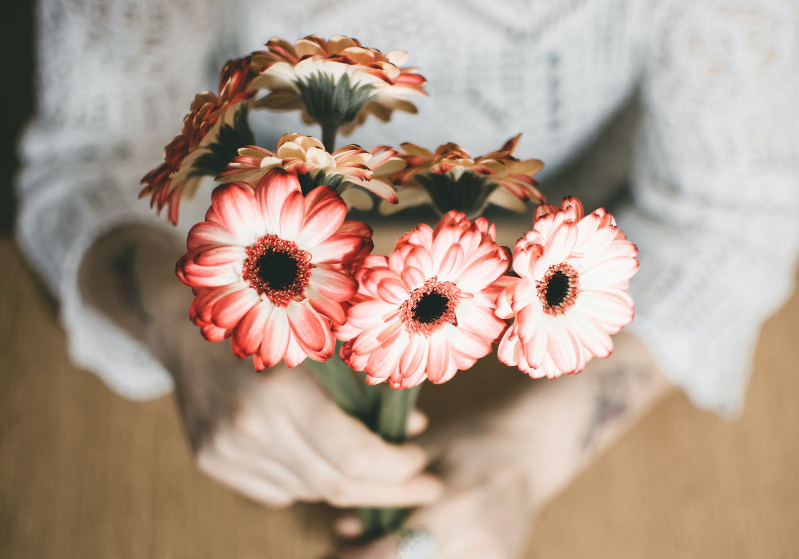 Mulher segurando flores vermelhas e brancas