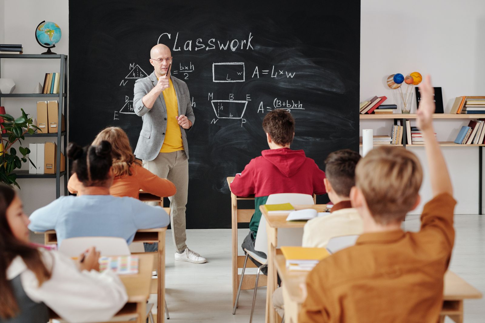 Professor na sala de aula ao lado da lousa